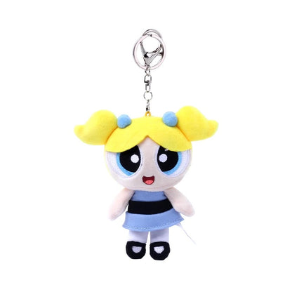 Plush keychain of a cartoon character with yellow hair and blue dress on a white background