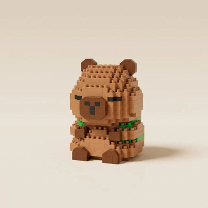 A small capybara figurine built from tan and brown micro-bricks, with a green collar, standing against a plain warm beige background.