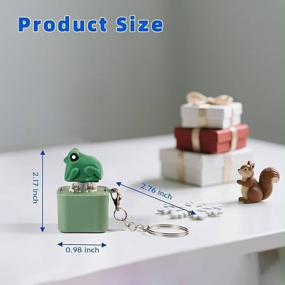 A small frog-shaped keychain in mint green is shown on a white tabletop with dimension arrows and text indicating 2.17 inches tall by 0.