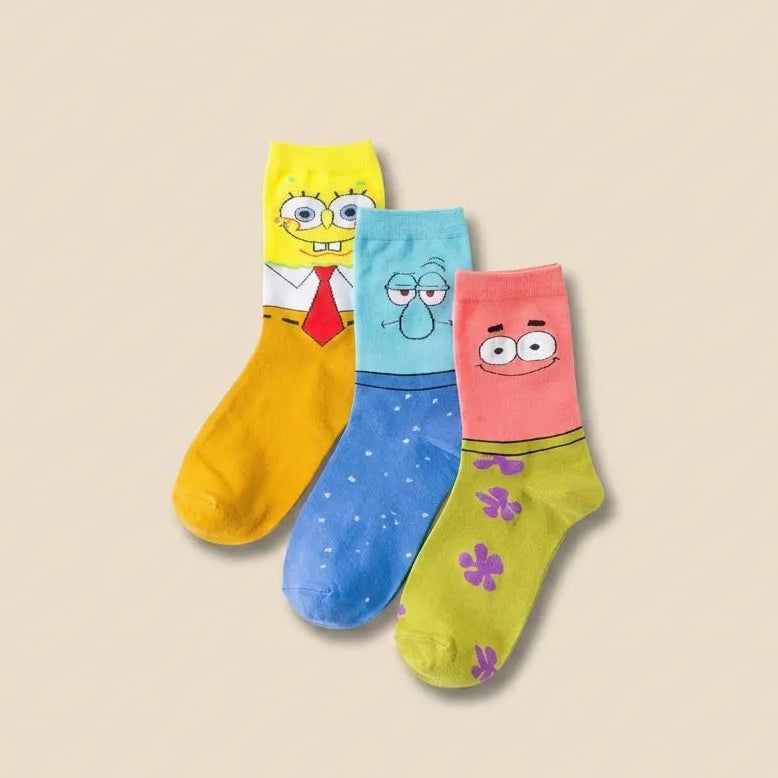 A 3-pack of cartoon socks featuring SpongeBob, Patrick, and Gary the clown, displayed on a solid beige background.