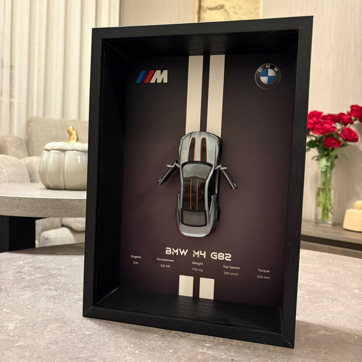 BMW M4 3D Framed Diecast Wall Art in a 32cm x 23cm black shadow box frame, featuring a grey 1:32 scale model car with open doors against an M-Power design background with performance stats.
